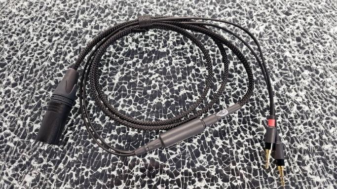 High-quality audio XLR to RCA cable with braided black sleeve on patterned surface, The Source AV
