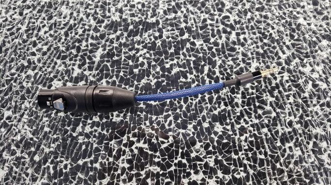 High quality audio adapter cable with black XLR and 2.5mm connectors on textured surface