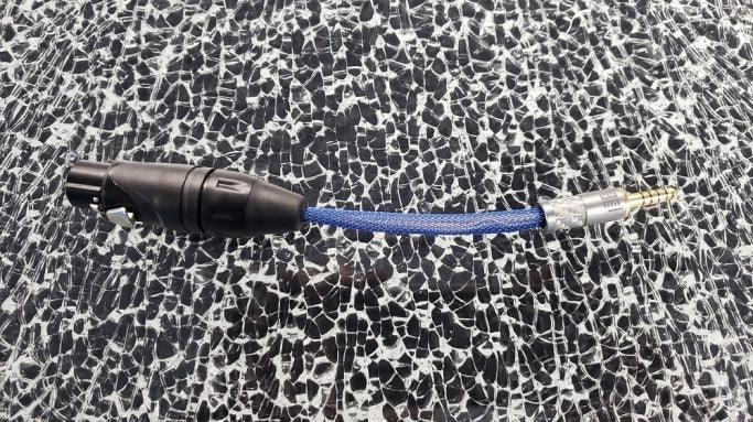High quality audio adapter cable with black XLR and 2.5mm connectors on textured surface