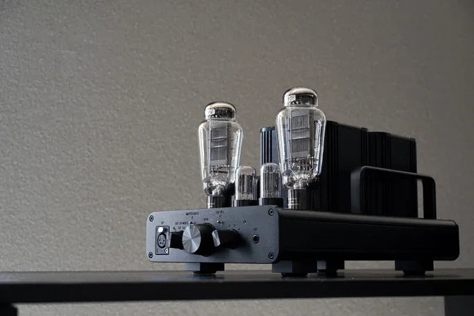 High-end black tube amplifiers for audio systems, featuring visible vacuum tubes, on white background